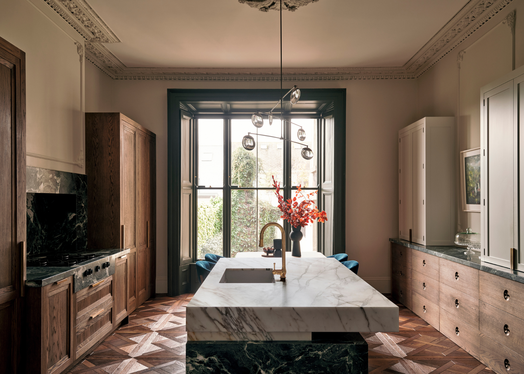 Victorian kitchen with crown molding, wooden cabinets, and a mixed marble island