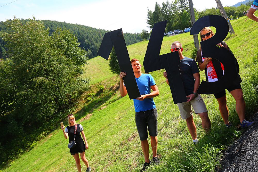 Fans wave Bjorg Lambrecht's bib no. 143 during the neutralised Tour de Pologne stage 4