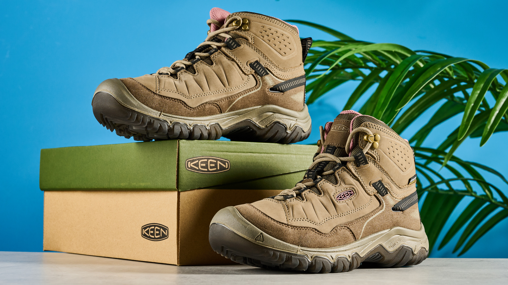 Keen Targhee IV hiking boots photographed in front of a blue background.