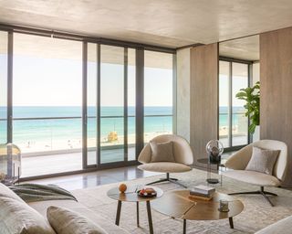 Neutral living room with sculptural shaped furniture in Miami beachside apartment