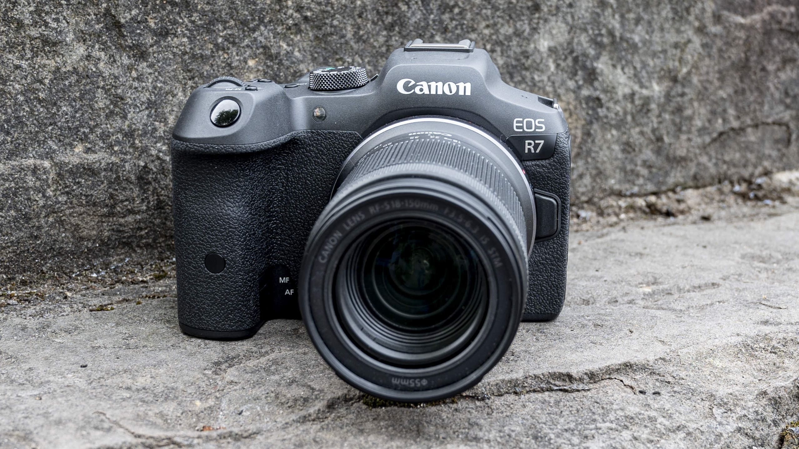 The Canon EOS R7 camera sitting on a stone step