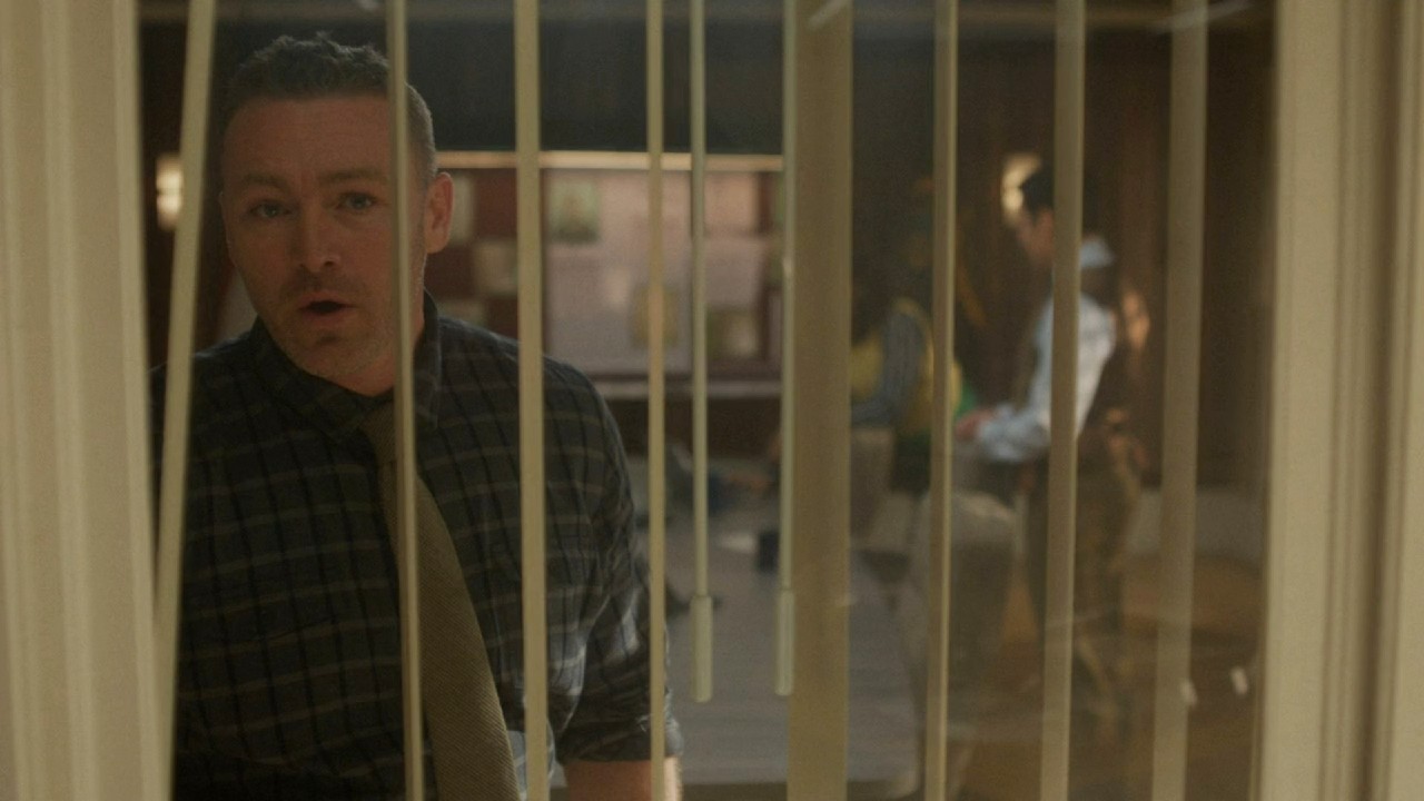 Jake McLaughlin looking out the window in Will Trent.