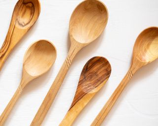 Wooden spoons lined up on white background
