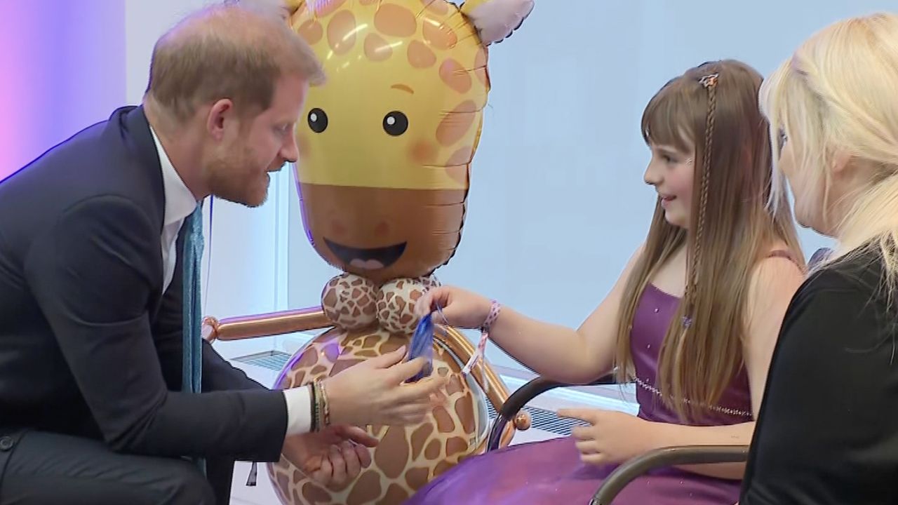 Prince Harry receiving a gift from Scarlett Cripps at WellChild Awards