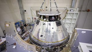 The Artemis I Orion spacecraft is lowered by crane after installation of the spacecraft adapter cone at the Kennedy Space Center on Aug. 20, 2020.