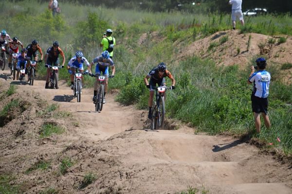 Mike Phillips leads Isaac Neff, Tyler Guathier across the dirt jump before the first section of singletrack, chased by teammates Darrin Braun and Chris Peariso.