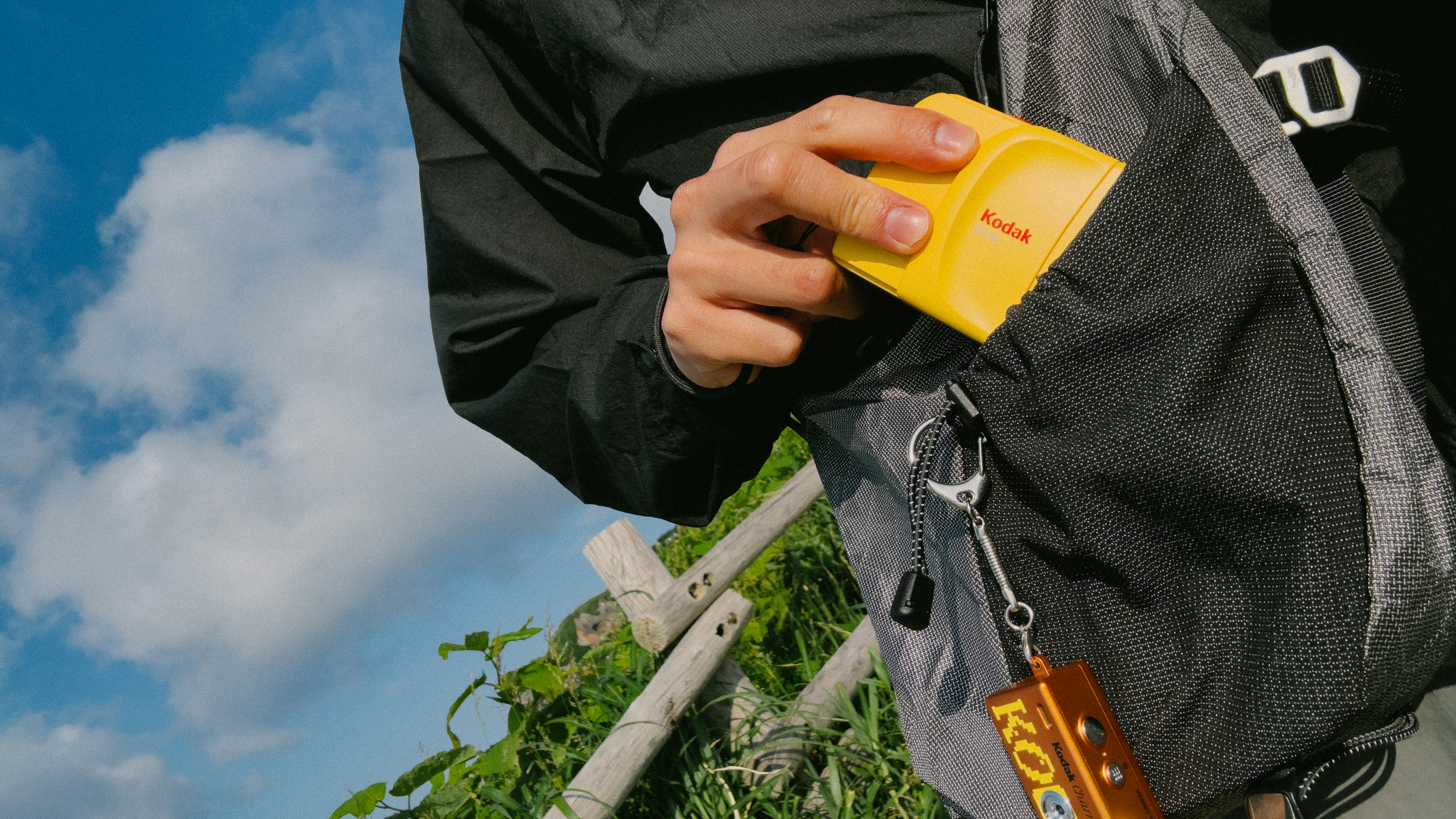 Photograph of the Kodak EC35 film camera being put inside a backpack outdoors