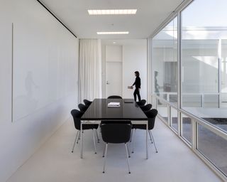 A meeting room at the Eskenazi School of Art with a long black table and a glass wall.