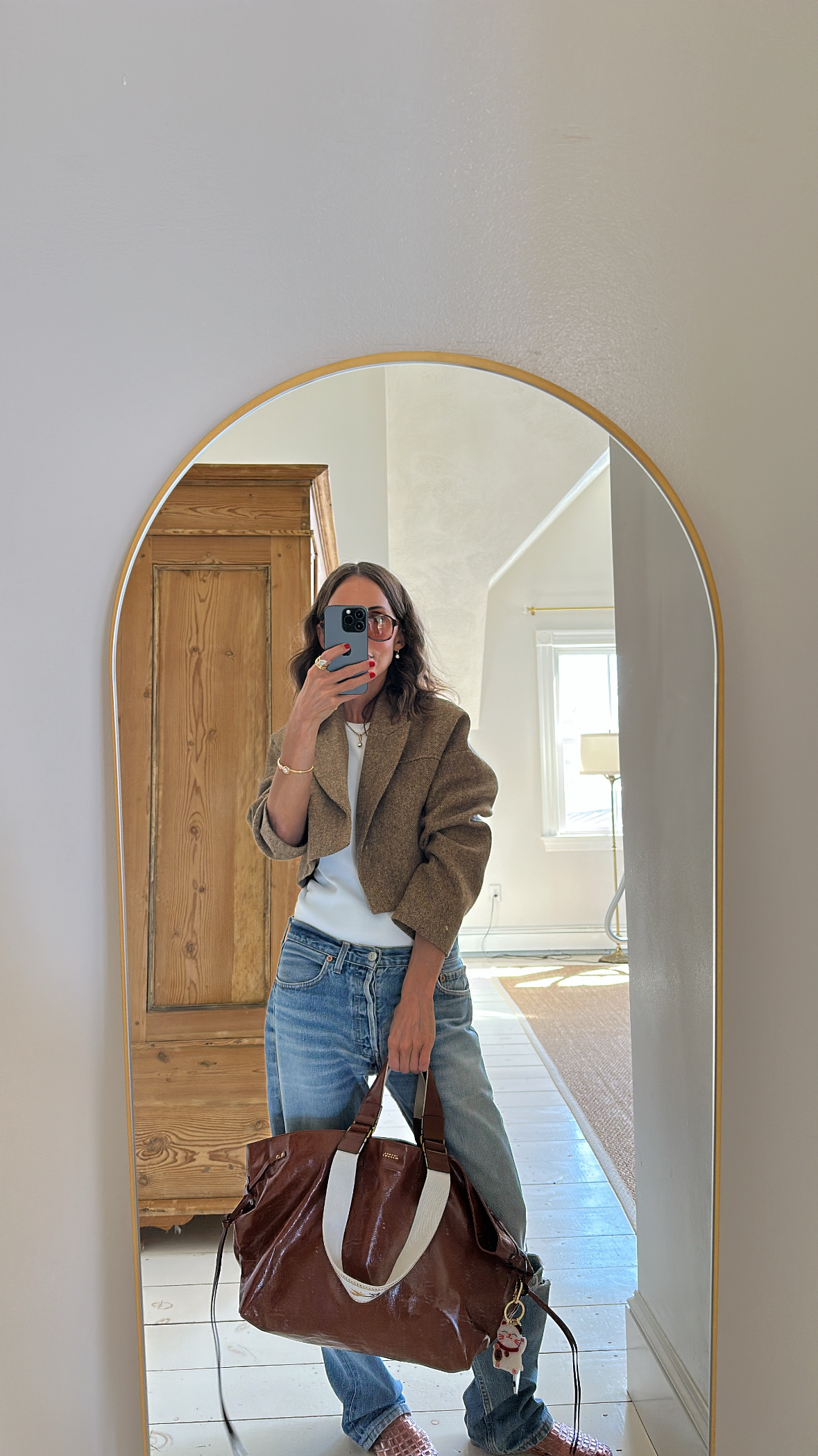Larissa Mills wearing a white tank top and blue jeans outfit