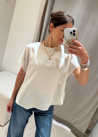 Woman in silk top and jeans.