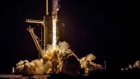 In the dark of night, a rocket blasts fire from its engines, sending plumes of smoke jetting out as it climbs the launch tower out of frame. A SpaceX Falcon-9 rocket launches from LC-39A, at NASA's Kennedy Space Center, in Floriday, carrying members of SpaceX's Crew-4 mission to the International Space Station, April 27, 2022.