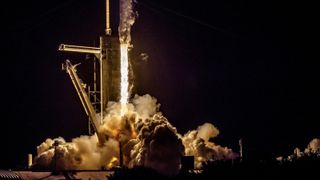 In the dark of night, a rocket blasts fire from its engines, sending plumes of smoke jetting out as it climbs the launch tower out of frame. A SpaceX Falcon-9 rocket launches from LC-39A, at NASA's Kennedy Space Center, in Floriday, carrying members of SpaceX's Crew-4 mission to the International Space Station, April 27, 2022.