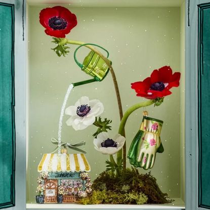 Still life display cabinet featuring garden-themed Christmas ornaments