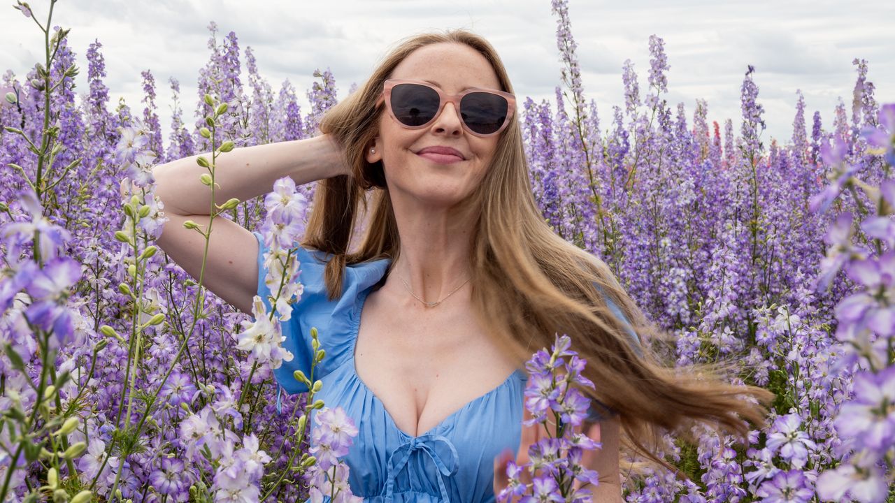 Blonde woman standing in a field of lilac flowers