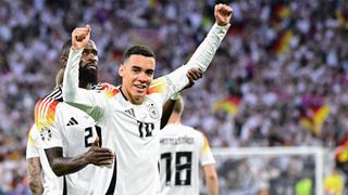 Hands aloft, Jamal Musiala celebrates scoring Germany's second goal in the team's 5-1 demolition of Scotland at Euro 2024.