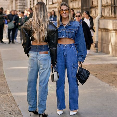 Two women wear denim outfits with jeans.