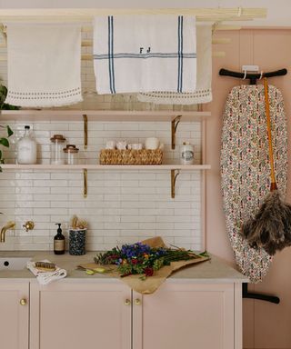 pink small utility room with sink and shelves and tiled splashback