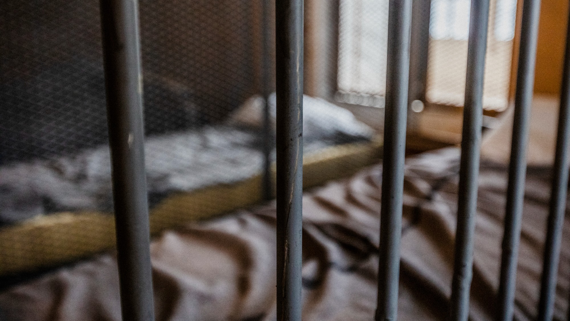 A jail cell with two small beds.