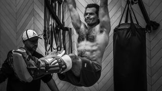 Henry Cavill doing shirtless pullups with a busted up leg