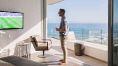 A man watching football in his beach side condo