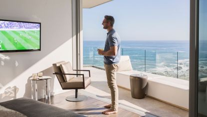 A man watching football in his beach side condo