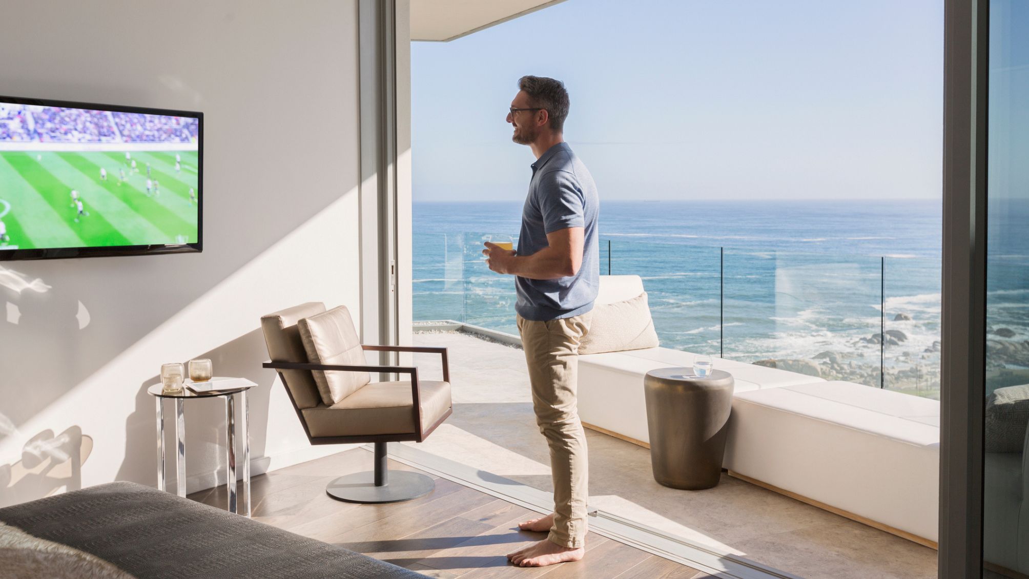 A man watching football in his beach side condo