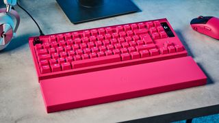 A photo of the Logitech G Pro X2 Rapid keyboard in hot pink on a stone surface