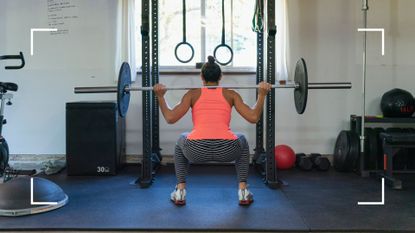 Woman doing a barbell squat, one of the many types of squats, at home gym with weights on either side