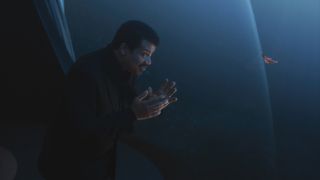 Host Neil deGrasse Tyson contemplates a flatworm, whose ancestors evolved some of the first brains, as it flutters in the sea outside the window of the Ship of the Imagination.