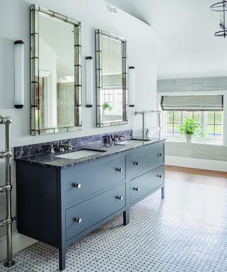white bathroom with his and hers washstand in dark blue, two mirrors and patterned floor