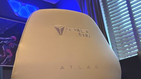 A Secretlab Atlas gaming chair in a home office during set-up and after it's completed.