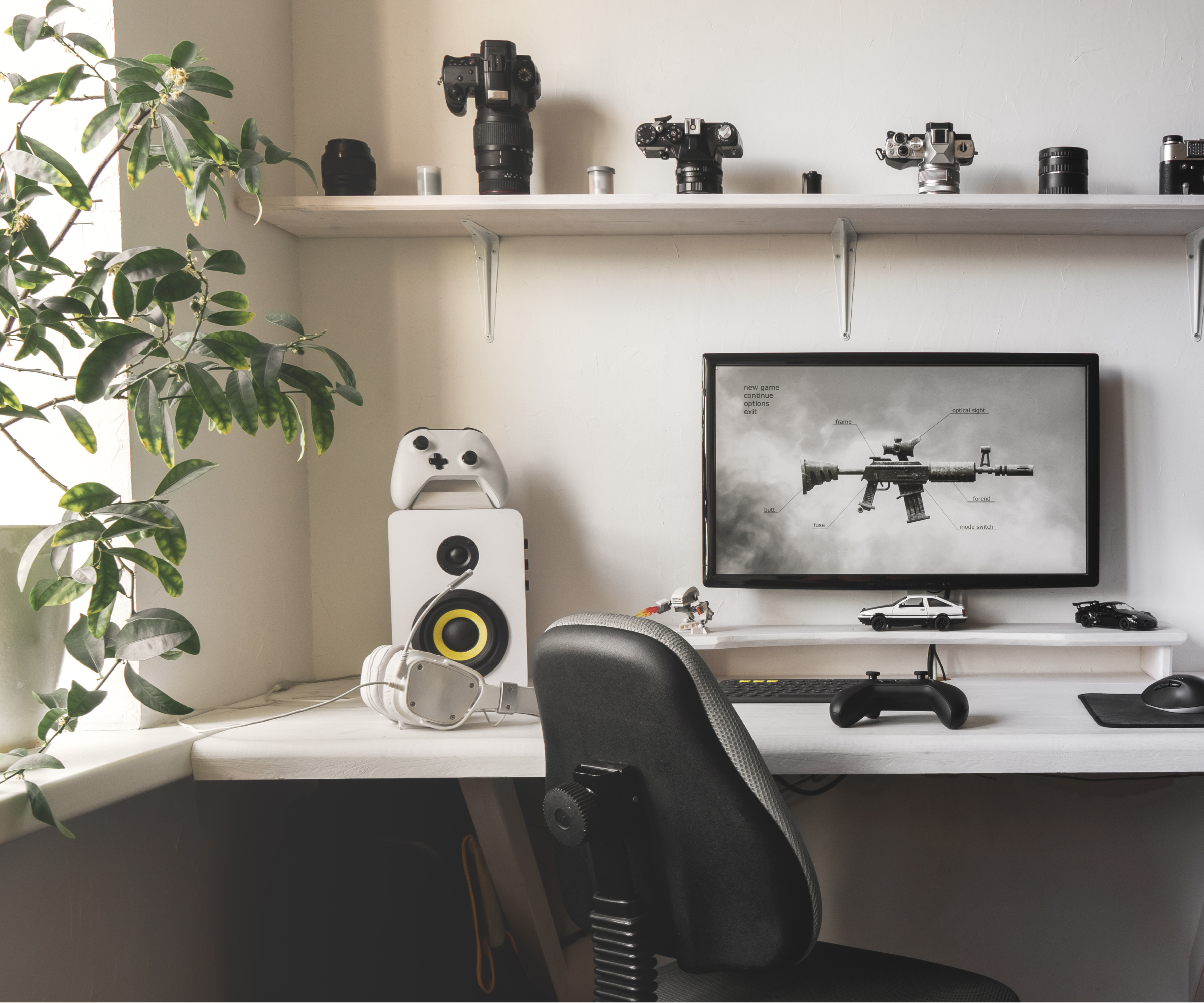 white desk with black chair, white shelf with vintage camera display