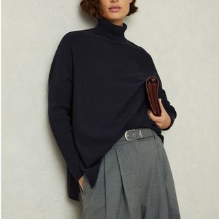 Image of woman wearing navy knitted jumper