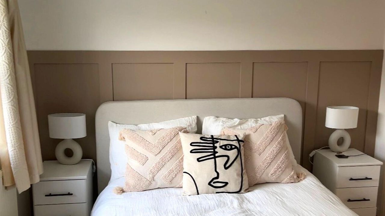 bedroom with wall panelling. and cushions on bed