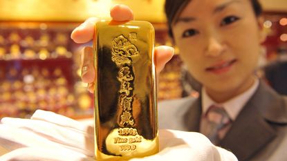 Chinese shop worker holding a gold bar