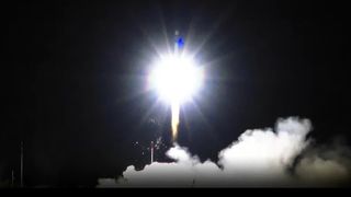 a rocket lifting off into the darkness