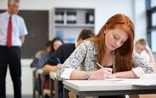 A close-up of a female ginger teenager sitting her AS and A Levels examinations