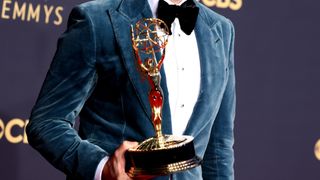 Emmy Award trophy and a man in a velvet tuxedo