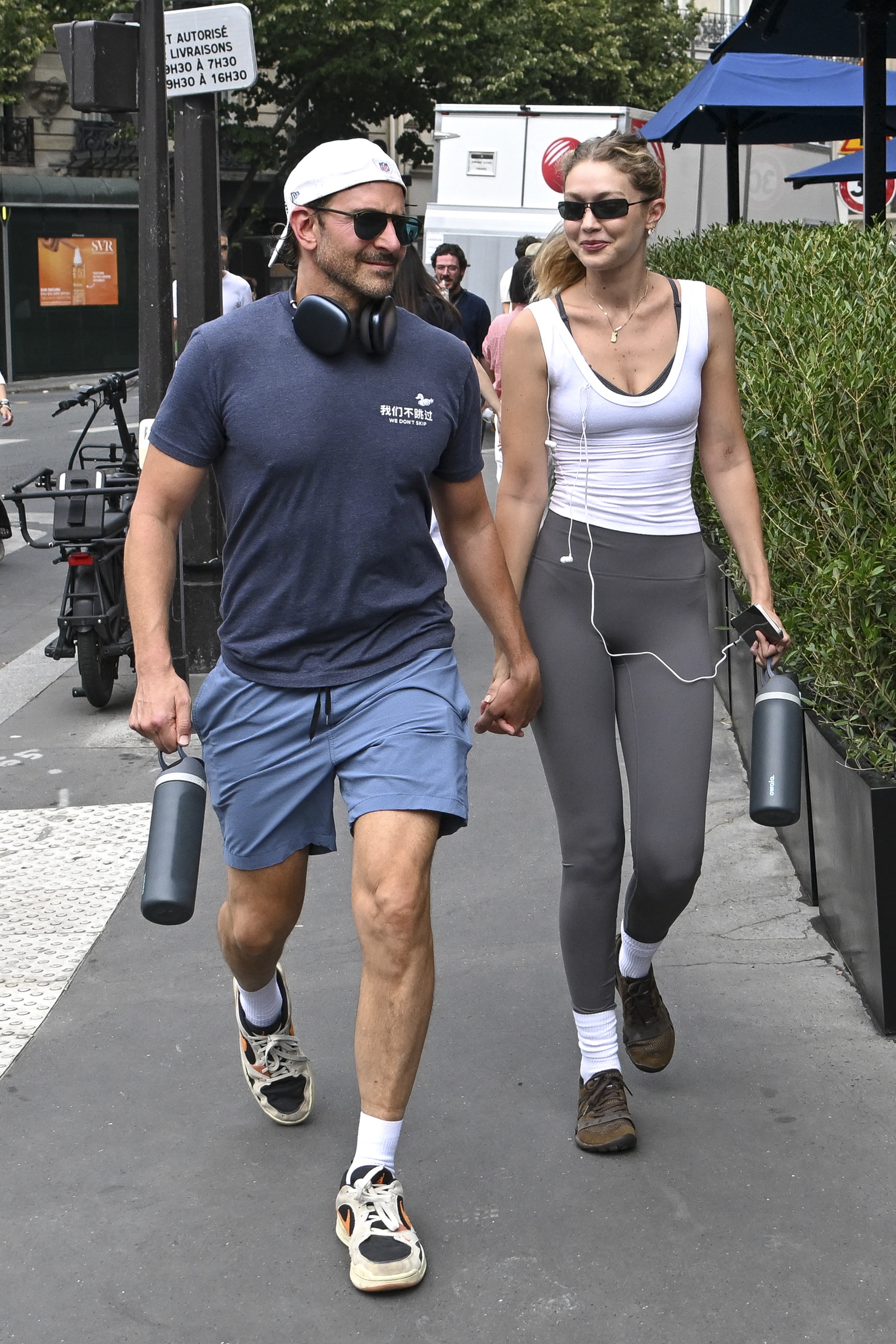 Bradley Cooper and Gigi Hadid in Paris on August 3. Hadid is wearing a white tank top over gray leggings.