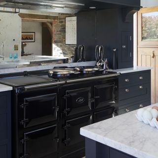 Kitchen with dark kitchen worktops and cabinets, marble kitchen island
