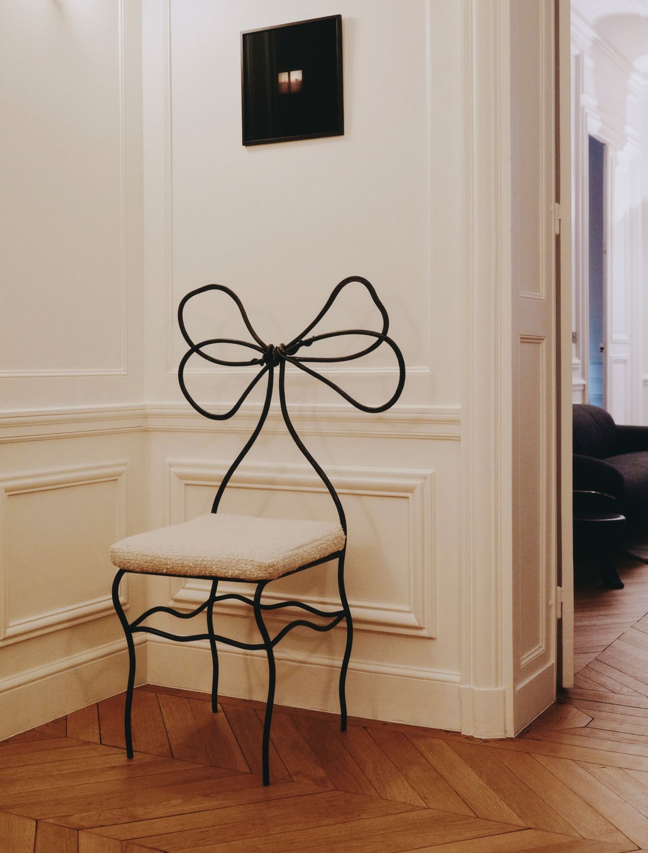 a bow chair in a hallway with parquet floors