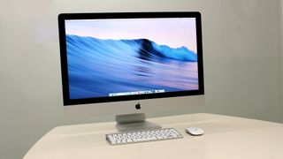 El iMac de 27 pulgadas con el fondo de pantalla predefinido colocado encima de una mesa
