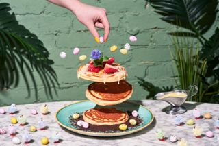 A pancake stack surrounded by mini eggs and Easter chicks