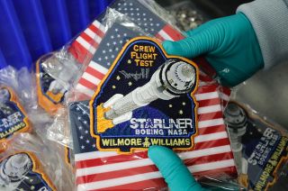 A mission patch is seen with an embroidered rocket and words saying "Crew Flight Test" and "Starliner Boeing NASA."