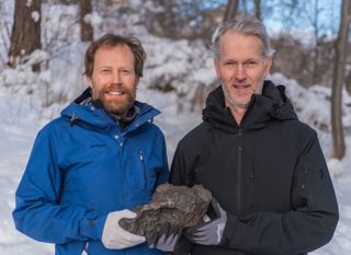 Geologists Andreas Forsberg and Anders Zetterqvist hold the meteorite they discovered, which fell over Sweden on Nov. 7, 2020.