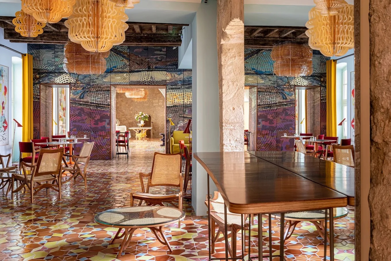 A textiles, tiles, and rattan-clad hotel boasts a kaleidoscopic atmosphere defined by vibrant colors, contrasting surfaces, and occasional worn rock accents.