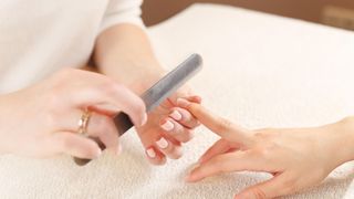 A person giving another person a manicure in a nail salon