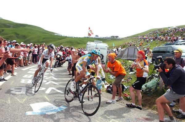 Alberto Contador (Astana) and Andy Schleck (Saxo Bank) are urged on by spectators on the upper slopes of the Col de la Madeleine .