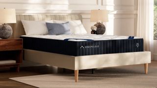 DreamCloud Classic Memory Foam Mattress on a beige platform bed frame in a sunny bedroom