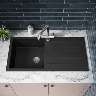 pink utility units with black sink and tile splashback